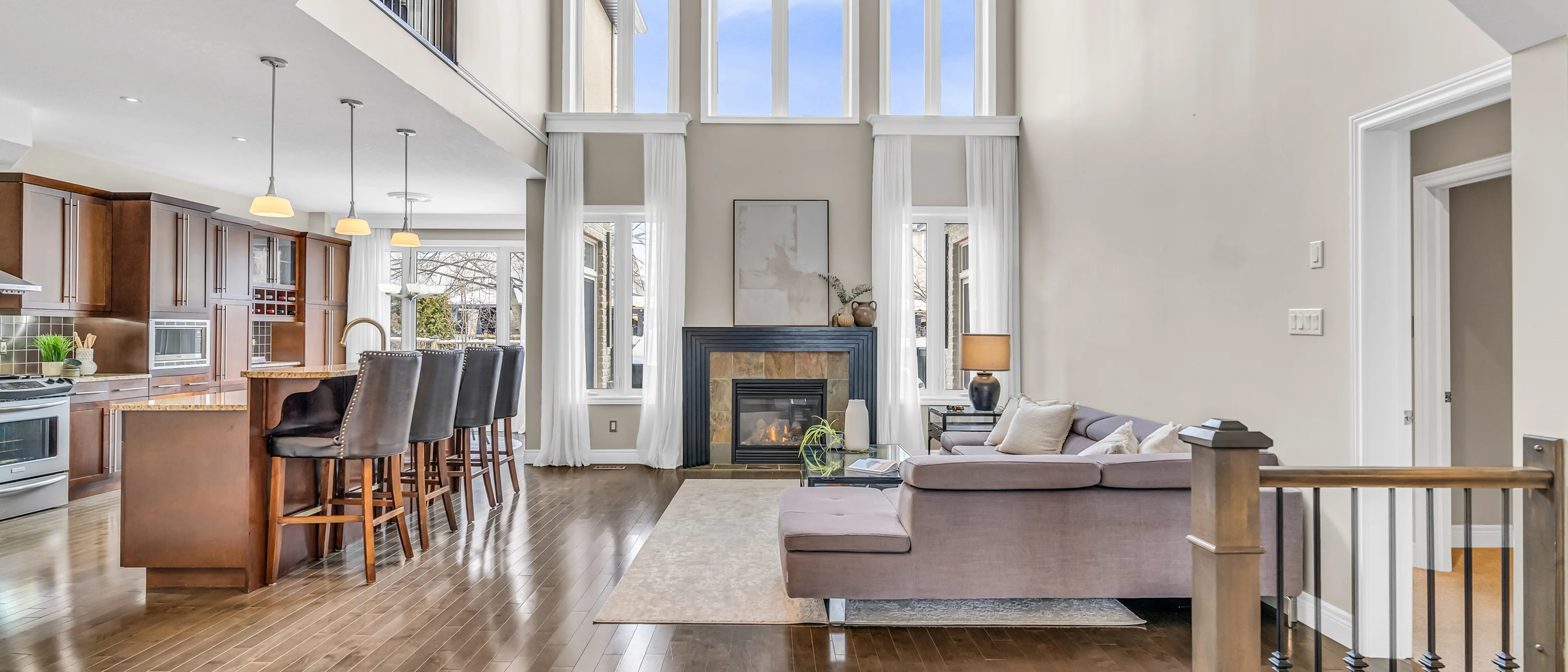 Two-storey great room with a fireplace and open kitchen beyond