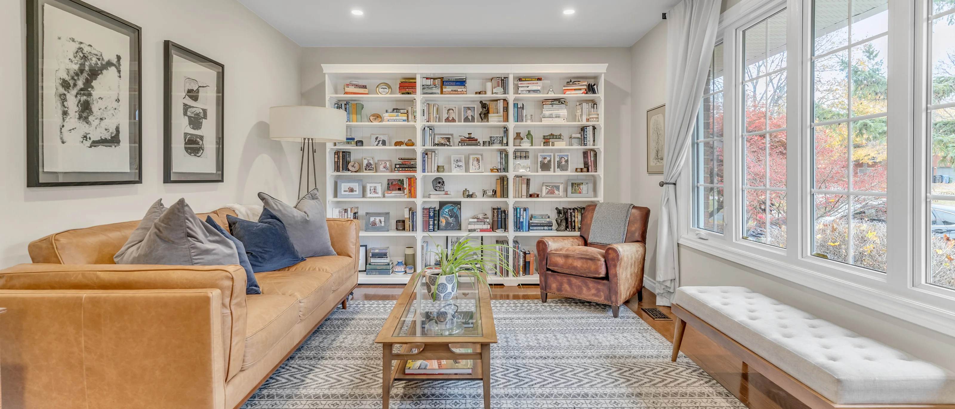 Living room with a tan leather sofa and a wall of built-in shelving