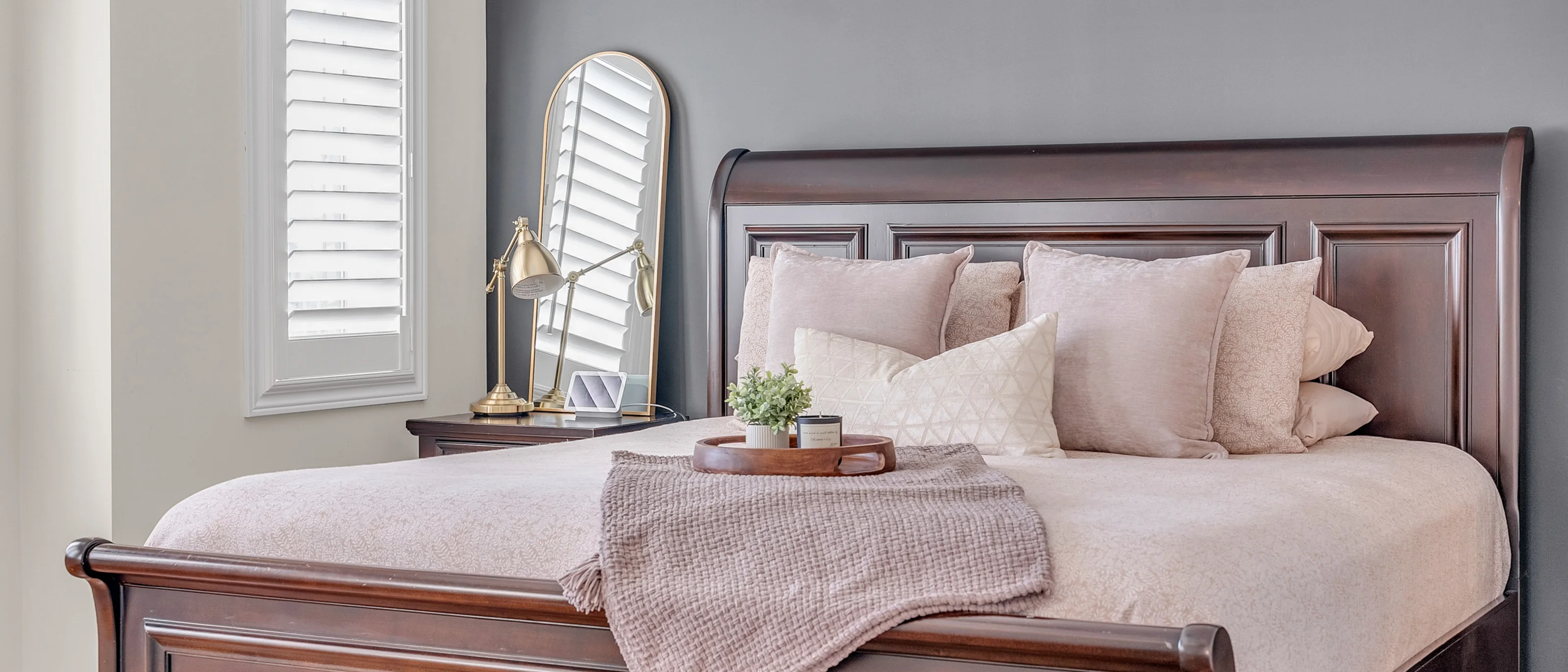 Primary bedroom with a dark wood sleigh bed and blush linens