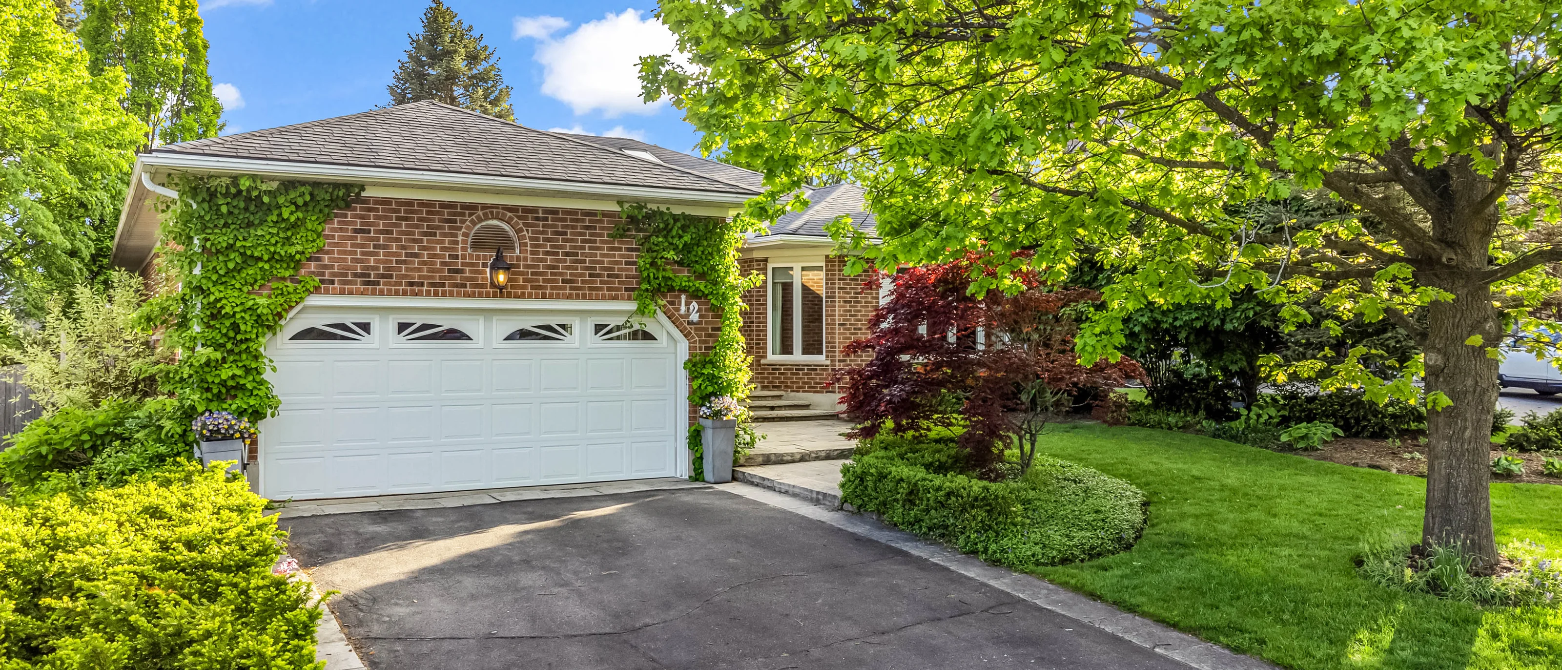 Brick bungalow exterior with a double garage and mature trees