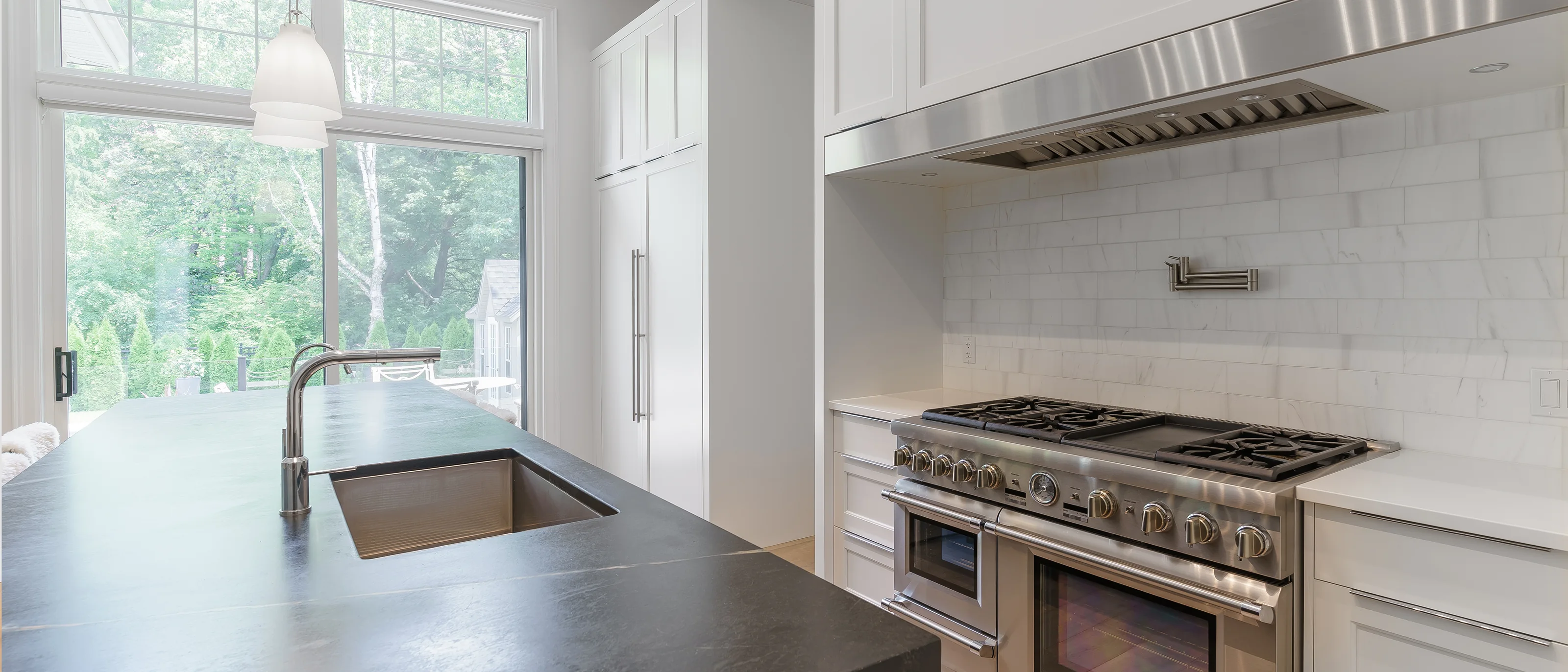 Modern kitchen with a professional range and marble backsplash