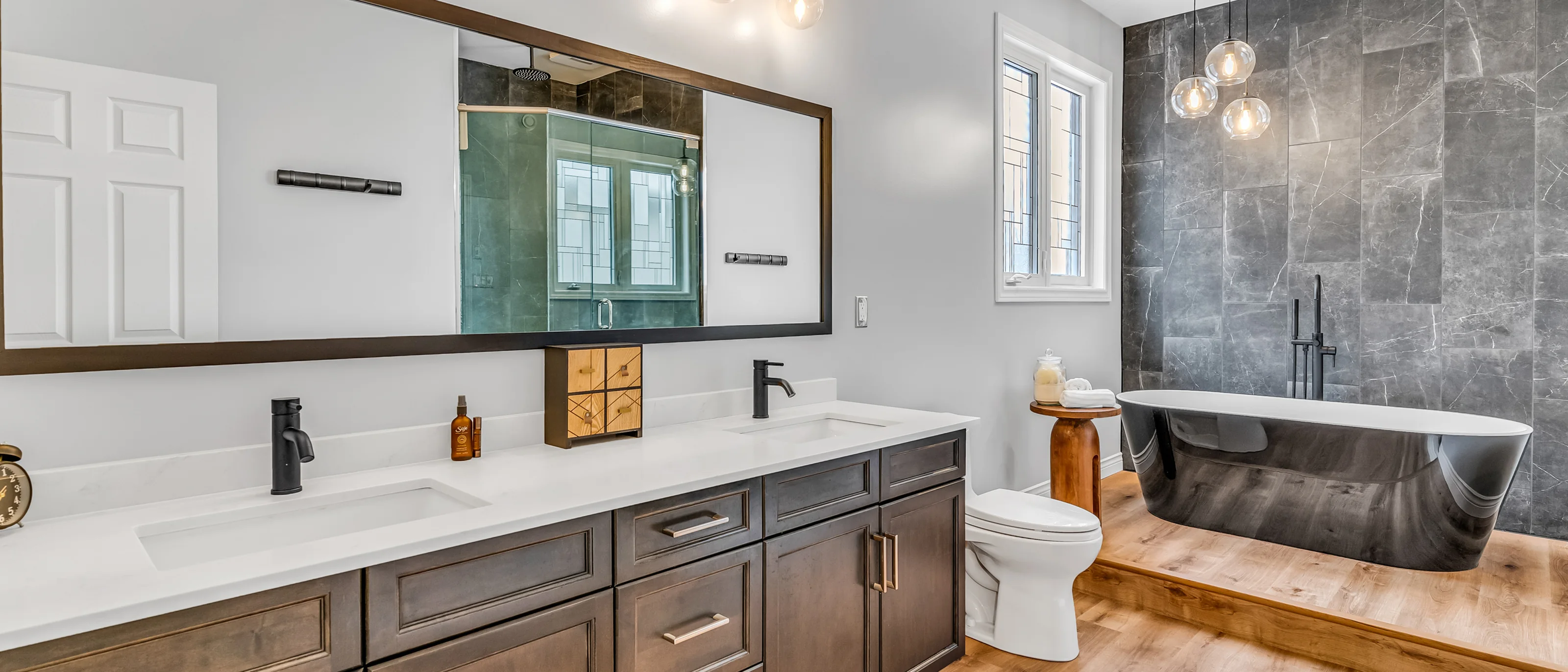 Ensuite with a double vanity, freestanding tub and slate tile